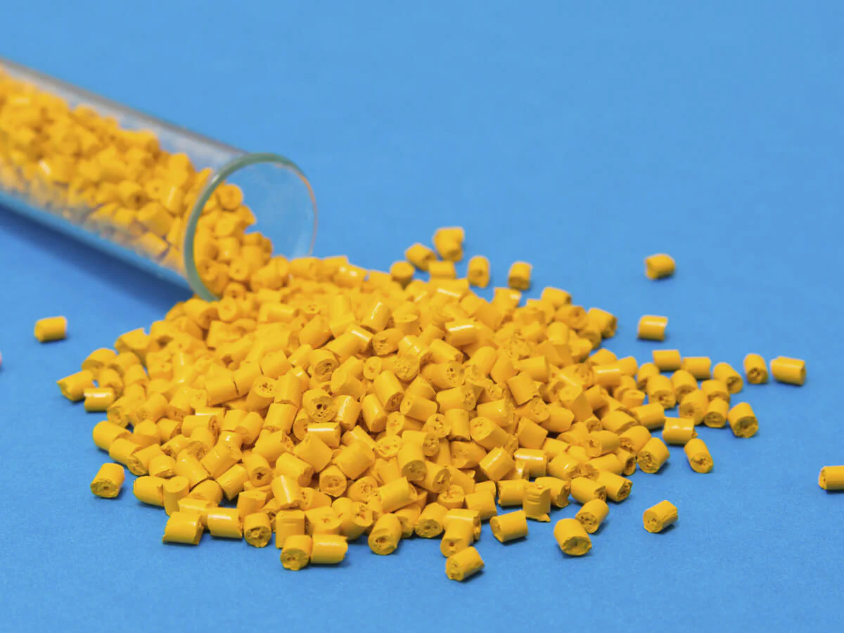 Kunststoff Bildbeschreibung / description: Gelbe Plastikpalletts rollen aus einem Reagenzglas auf blauem Untergrund